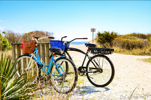 Two bicycles parked beside a sandy coastal path